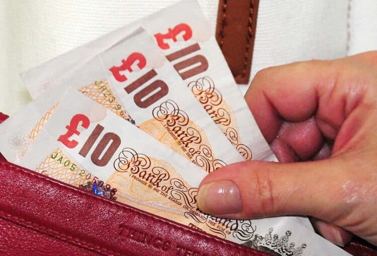 General view of ten pound notes in a purse.